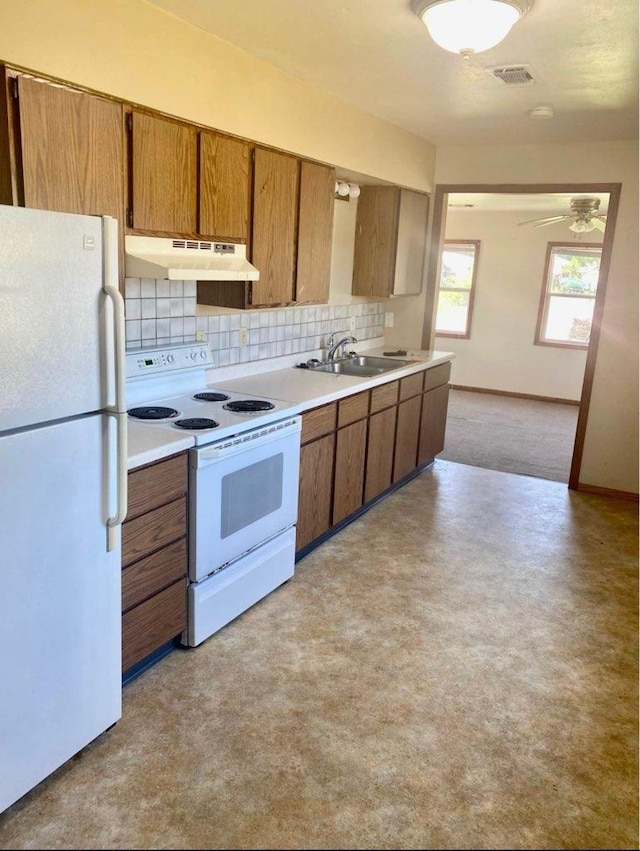 800 Thompson St, Portage, WI 53901 - kitchen featuring white appliances, under cabinet range hood, tasteful backsplash, light countertops, and brown cabinets