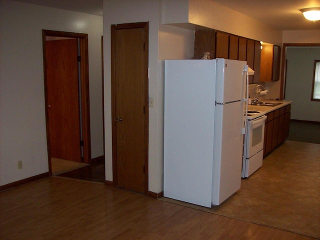 800 Thompson St, Portage, WI 53901 - kitchen featuring white appliances, light wood-style floors, light countertops, and brown cabinets