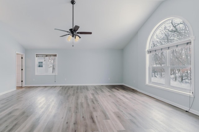 unfurnished living room featuring light wood-style floors, vaulted ceiling, baseboards, and ceiling fan