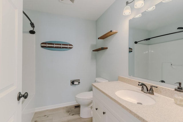 full bath featuring a shower, toilet, vanity, wood finished floors, and baseboards