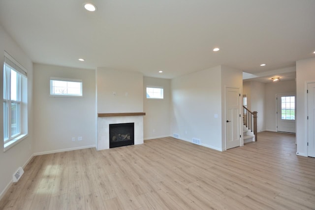 W198N5372 Boxwood Blvd, Menomonee Falls, WI 53051 - unfurnished living room featuring recessed lighting, stairs, light wood finished floors, plenty of natural light, and baseboards