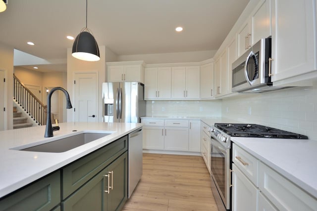 W198N5372 Boxwood Blvd, Menomonee Falls, WI 53051 - kitchen featuring stainless steel appliances, a sink, light countertops, white cabinetry, and light wood-style floors
