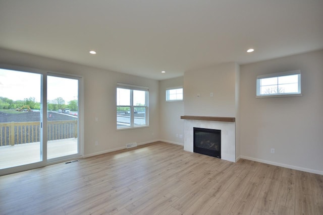 W198N5372 Boxwood Blvd, Menomonee Falls, WI 53051 - unfurnished living room featuring light wood-type flooring, recessed lighting, baseboards, and a glass covered fireplace