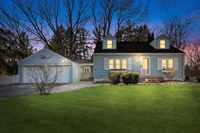 new england style home featuring an outbuilding, a front yard, fence, a garage, and driveway