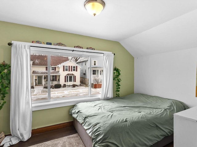 bedroom featuring lofted ceiling and wood finished floors