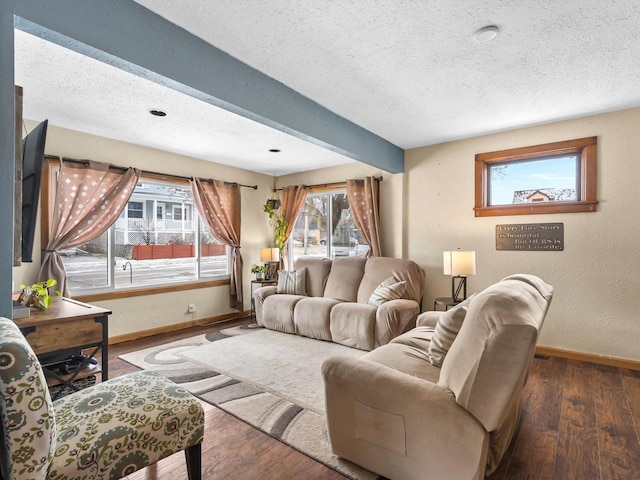 living room with a textured wall, a textured ceiling, baseboards, and wood finished floors