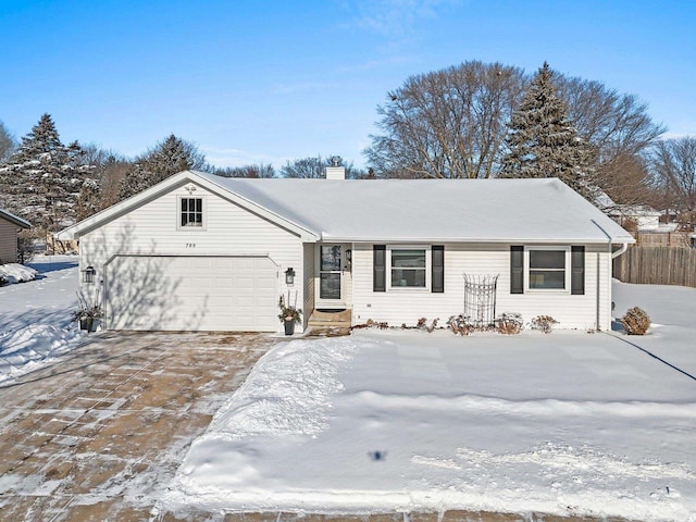 ranch-style house with a garage, driveway, and a chimney