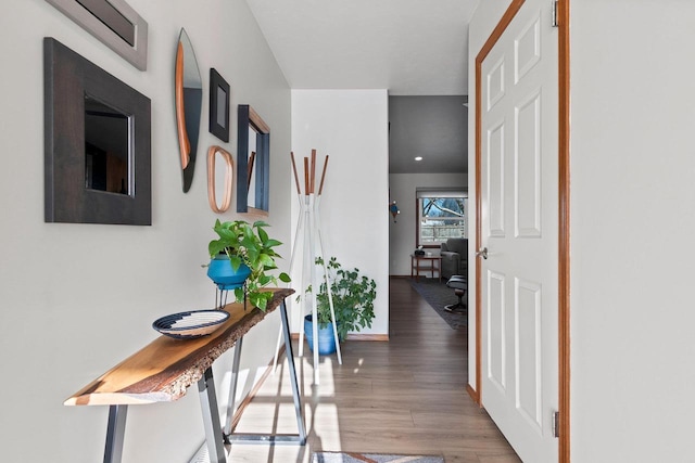 hall featuring baseboards and wood finished floors