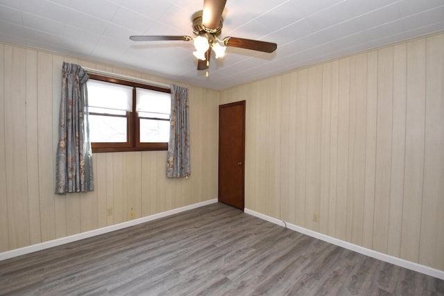 spare room with ceiling fan, baseboards, and wood finished floors