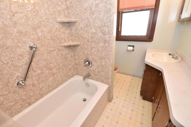 bathroom featuring toilet, vanity, baseboards, shower / washtub combination, and tile patterned floors