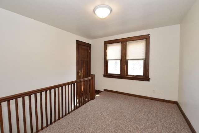 carpeted spare room featuring baseboards