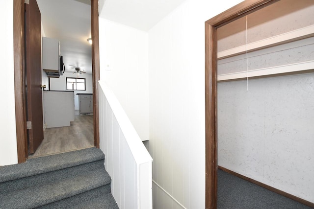 stairs featuring attic access, baseboards, and wood finished floors