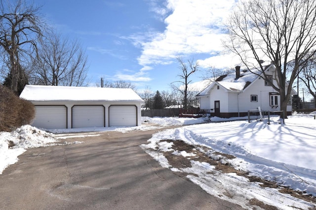 exterior space featuring a detached garage, an outdoor structure, and fence