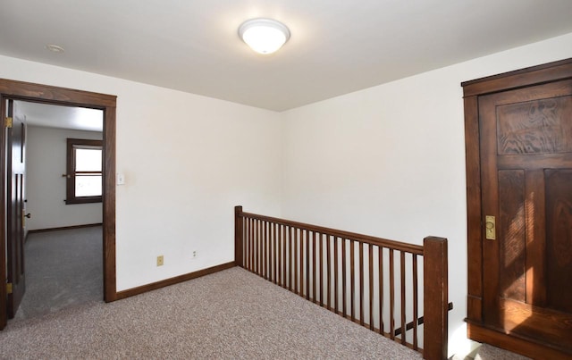 carpeted spare room featuring baseboards