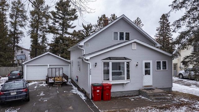 view of front of house featuring a garage, an outdoor structure, and a chimney