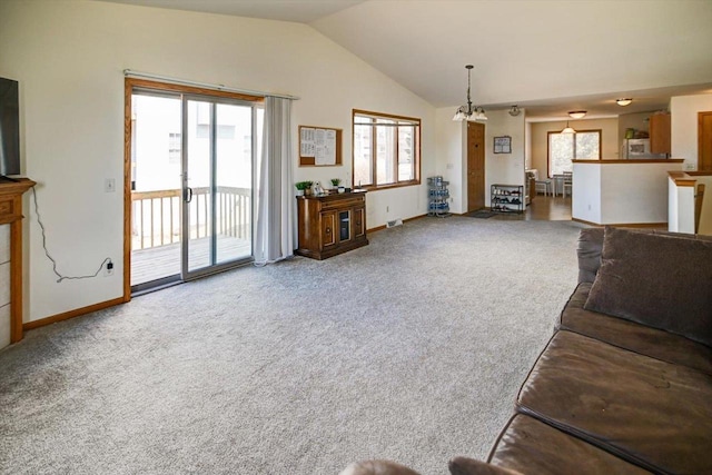 living area with baseboards, carpet floors, a chandelier, and vaulted ceiling