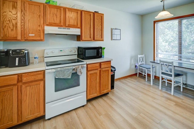 kitchen with black microwave, under cabinet range hood, light wood-type flooring, light countertops, and white electric range