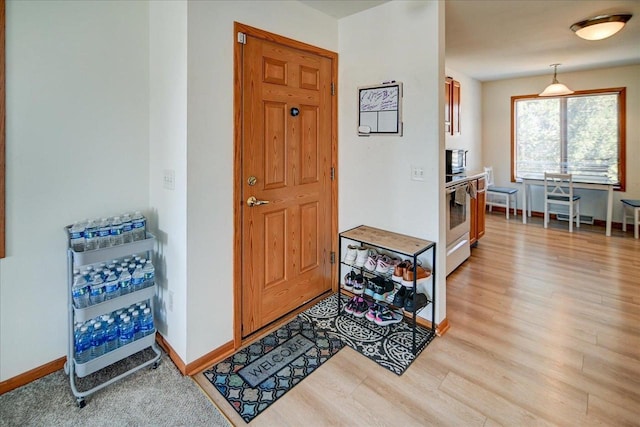 entrance foyer featuring light wood finished floors and baseboards