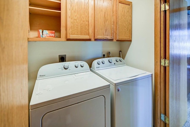 washroom with cabinet space and separate washer and dryer