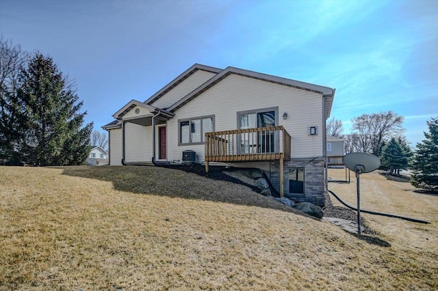 view of front of home featuring a deck, a front yard, and central AC unit