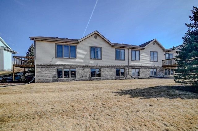 back of house featuring a lawn and a wooden deck