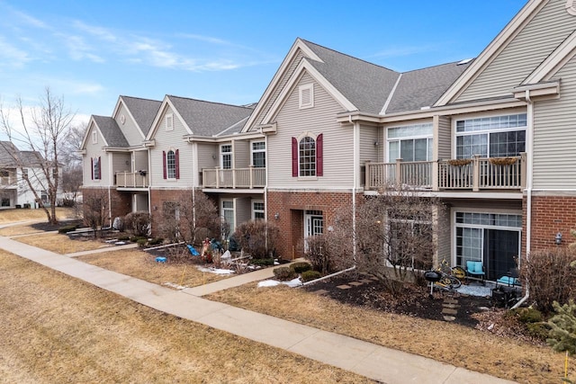 townhome / multi-family property featuring brick siding and a front lawn