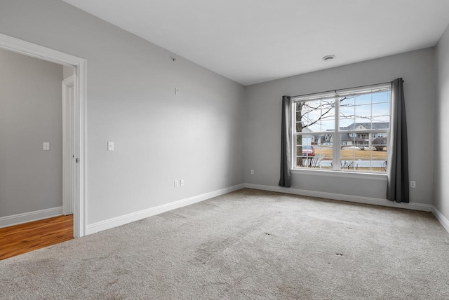 carpeted spare room with baseboards