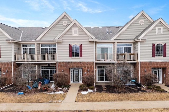 multi unit property featuring brick siding and roof with shingles