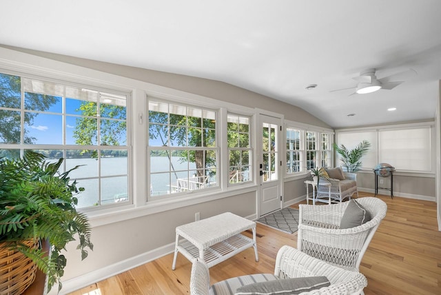 sunroom / solarium featuring a water view, vaulted ceiling, and ceiling fan