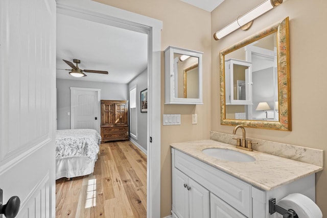 bathroom featuring a ceiling fan, vanity, ensuite bathroom, and wood finished floors