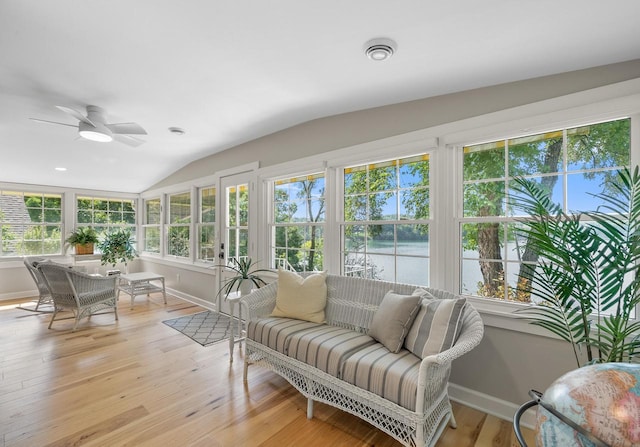 sunroom / solarium with lofted ceiling, a water view, ceiling fan, and visible vents