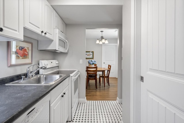 kitchen featuring white appliances, white cabinetry, and a sink