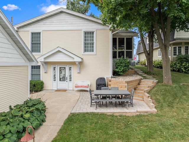 back of house featuring a lawn and a patio area