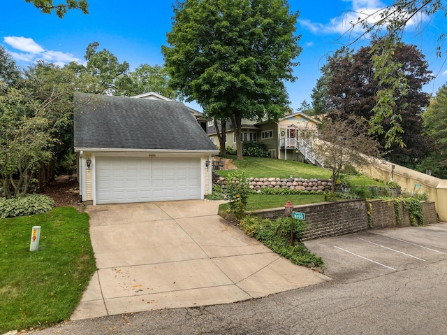 view of front facade featuring a garage, a front lawn, roof with shingles, and fence