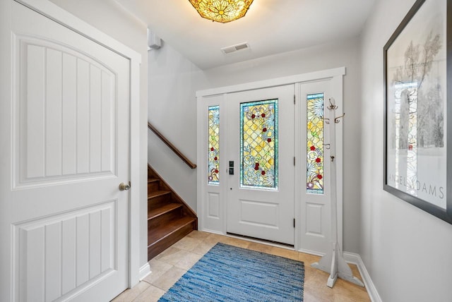 entryway featuring stairs, light tile patterned floors, visible vents, and baseboards