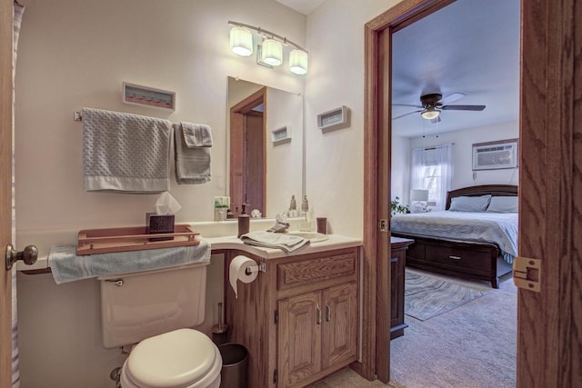 bathroom featuring toilet, a wall mounted AC, ensuite bathroom, ceiling fan, and vanity