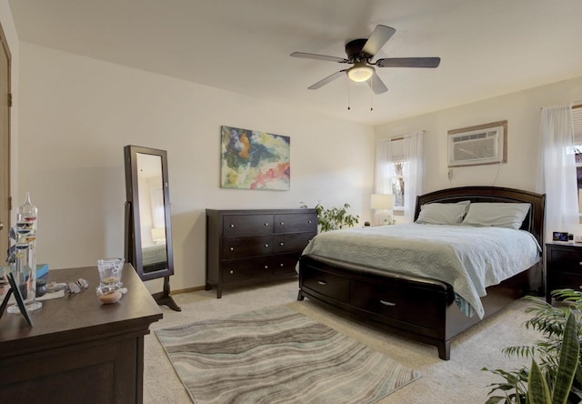 bedroom featuring ceiling fan, baseboards, light colored carpet, and a wall mounted AC