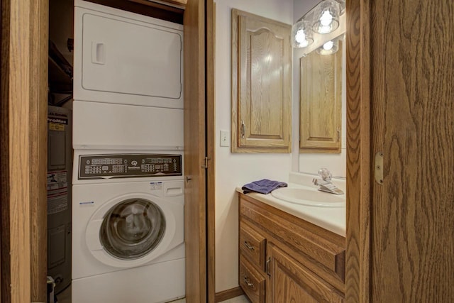 clothes washing area featuring laundry area, a sink, and stacked washer / drying machine