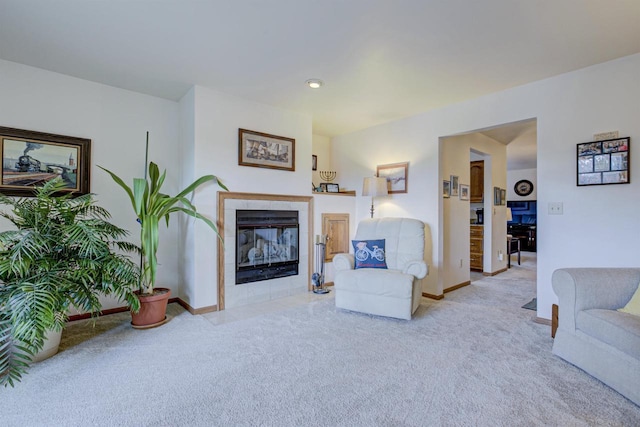 carpeted living room featuring a tile fireplace and baseboards