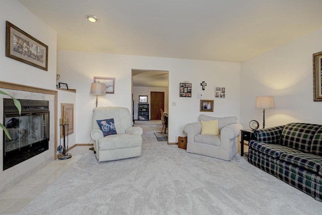 living room featuring carpet floors, a tiled fireplace, and baseboards