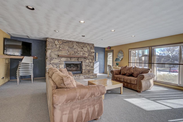 living room with carpet floors, recessed lighting, a stone fireplace, and baseboards