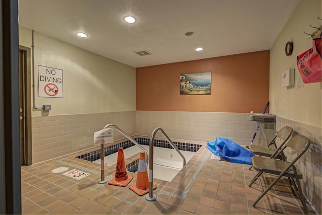 rec room featuring wainscoting, visible vents, tile walls, and recessed lighting