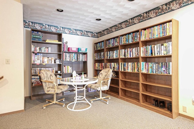 sitting room with carpet flooring, a textured ceiling, and baseboards