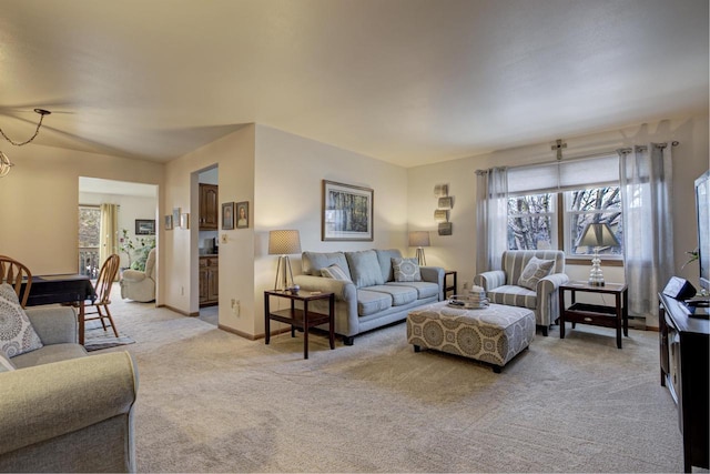 living area featuring light carpet and baseboards