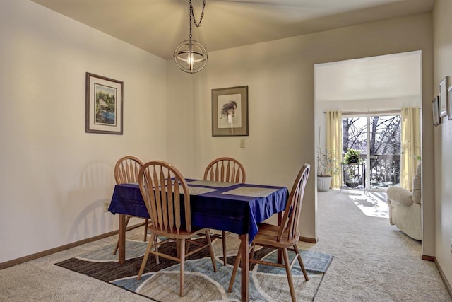 carpeted dining room featuring baseboards