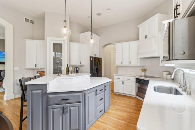 kitchen with white cabinets, black appliances, gray cabinets, and a sink