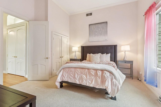 bedroom featuring baseboards, visible vents, ornamental molding, carpet, and a closet