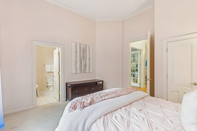 bedroom featuring ornamental molding, baseboards, carpet floors, and ensuite bath