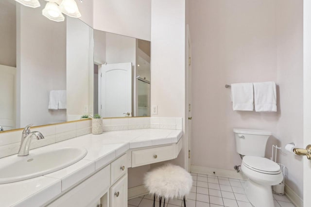 bathroom featuring baseboards, toilet, a shower with door, tile patterned floors, and vanity