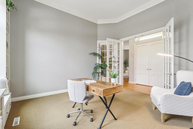 carpeted office space featuring visible vents, crown molding, and baseboards